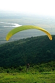 paragliding, paratrooper, jumping, parachute, parachutist, territory, hill, hillside, countryside, nature, forest, grass, tree, green, river, standing, glider, cow, dangerous, sport, Tokaj, TV, transmitter, place, sportman, alone, yellow, field, mountain, high, brave, bravery, courage, audacity, , evening, setting, sun, ray, rays, critter, haze, steam, vapor, perspective, distance, from the top, running leap, bound, leap, red, helmet, rope, crab, control, dictate, down, up, to the right, to the left, to lift off, to circle round, landing, to climb down, touch-down, trees, bushes, television, tower, near, past, parking, meadow, range, pasture, grazer, arable, clod, earth, ploughland, tillage, spare-time, leisure, time, Kiss L�szl�, L�szl� Kiss