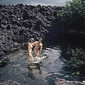 naked, stripped, nudist couple, nudist pair, naturism, naturist couple, nudist, naturist, beach, coast, nudism, rock coast, stony, craggy, bay, gulf, clear, hygienic, pure, clean, Hawaii, Kona, Honokohau, Queen s bath, 1987, man, woman, bath, bath, bathe, bathing, water, stone, stones, rock, scrag, bush, CD 0090