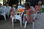 naturism, naturist, nudism, nudist, fkk, INF, NFN, unclad, stripped, naked, in a state of nature, in the buff, in the nude, beach, naturist beach, visitor, naturist guest, naturism club, naturist beach and camping, hospitality, bar, pub, buffet, canteen, tables, chairs, sunshade, shady, adumbral, shaded, woman, man, kid, game, bean, ball, to play, puppeteer, amuse, entertain, tree, trees, lake, lake side, 2007, CD 0051, Kiss L�szl�, L�szl� Kiss